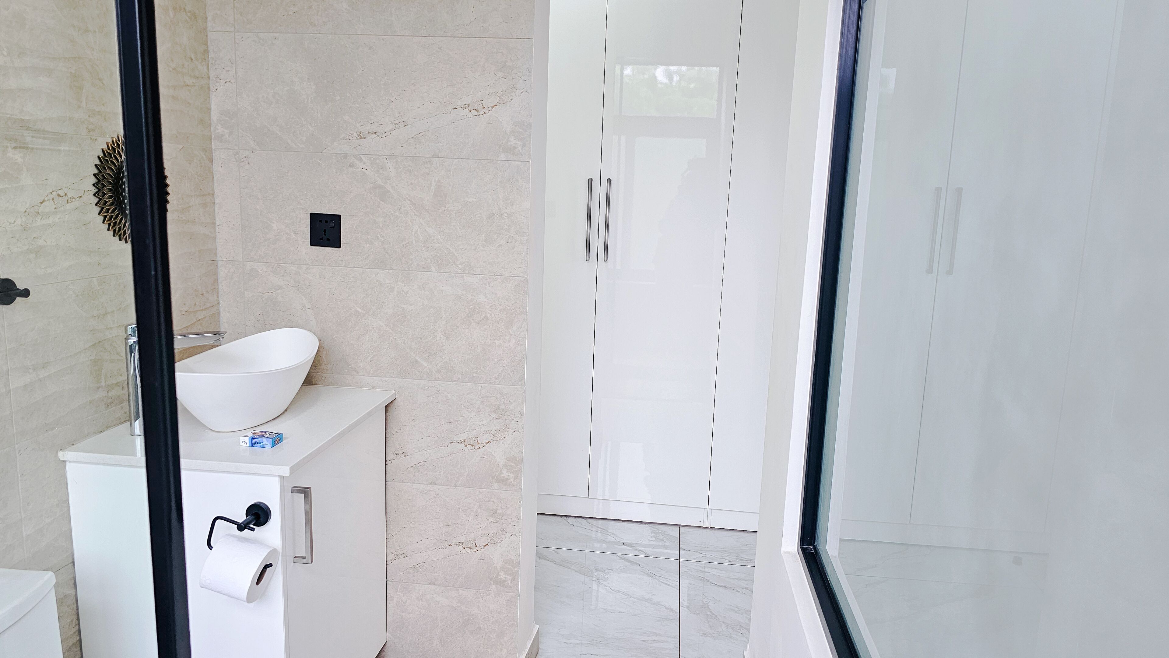 A bathroom with a white sink, toilet, and shower area.