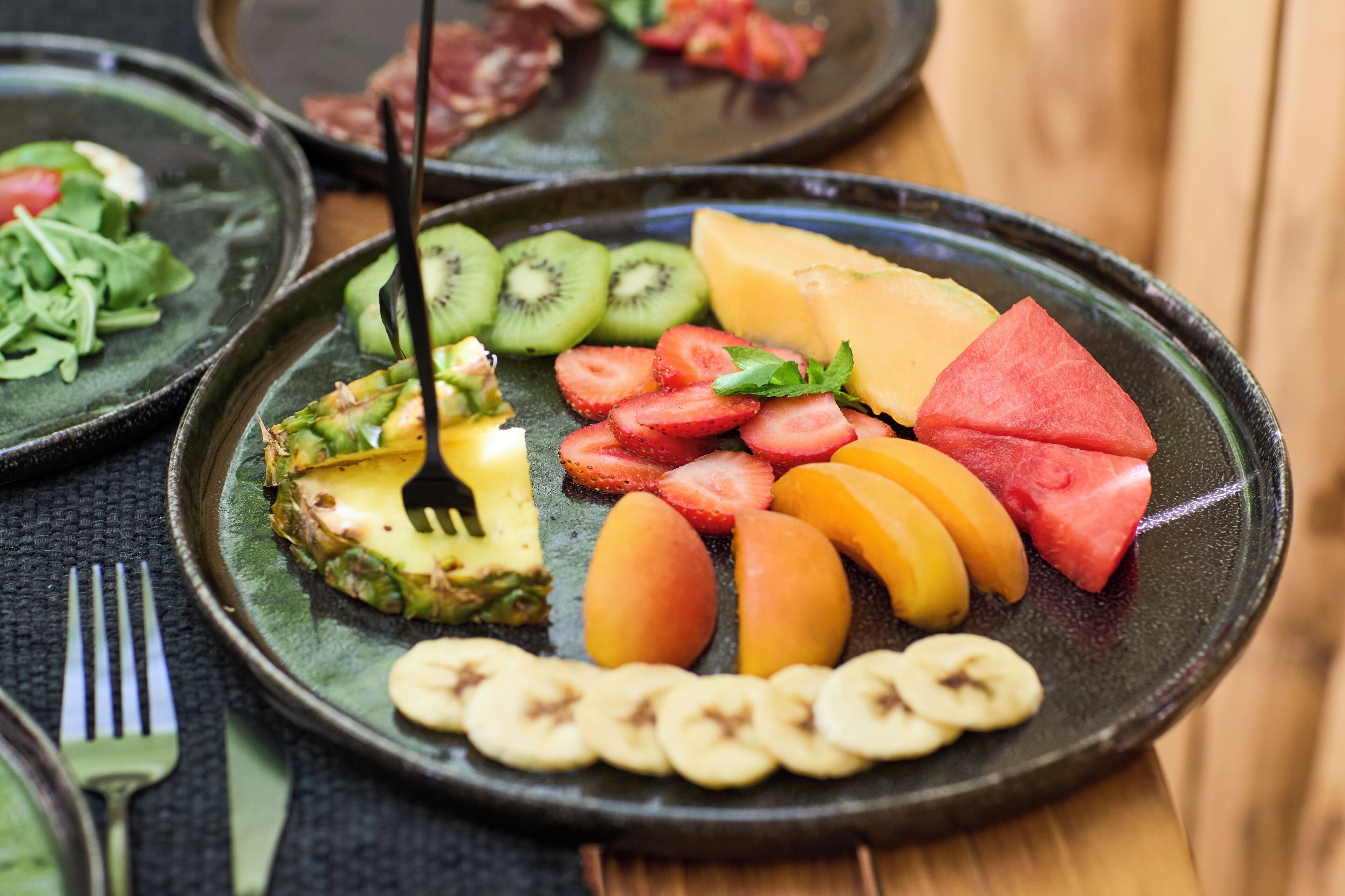 Un plato con varias frutas y un tenedor.