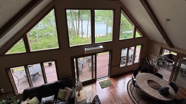 Una habitación amplia con techo alto y grandes ventanales con vistas a un lago.