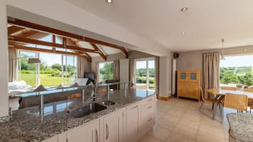 Una cocina moderna con encimeras de granito, un lavamanos integrado y una zona de comedor con mesa y sillas.