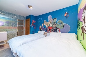 Un dormitorio con dos camas, un mural en la pared y un baño con ducha.