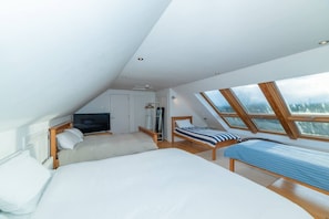 A bedroom with a large bed, a television, and a skylight. - Stunning North Coast Villa, River View Hot Tub 20+ (Coleraine)