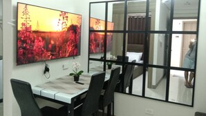 A dining area with a table, chairs, and a large mirror reflecting the room.