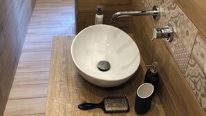 A bathroom with a wooden vanity, a white sink, a handheld brush, a cup, and a bottle of hand soap. - CasaCondo on Golden Mile - Twin Apartments by UNESCO Wonders for Large Groups (Torre del Greco)