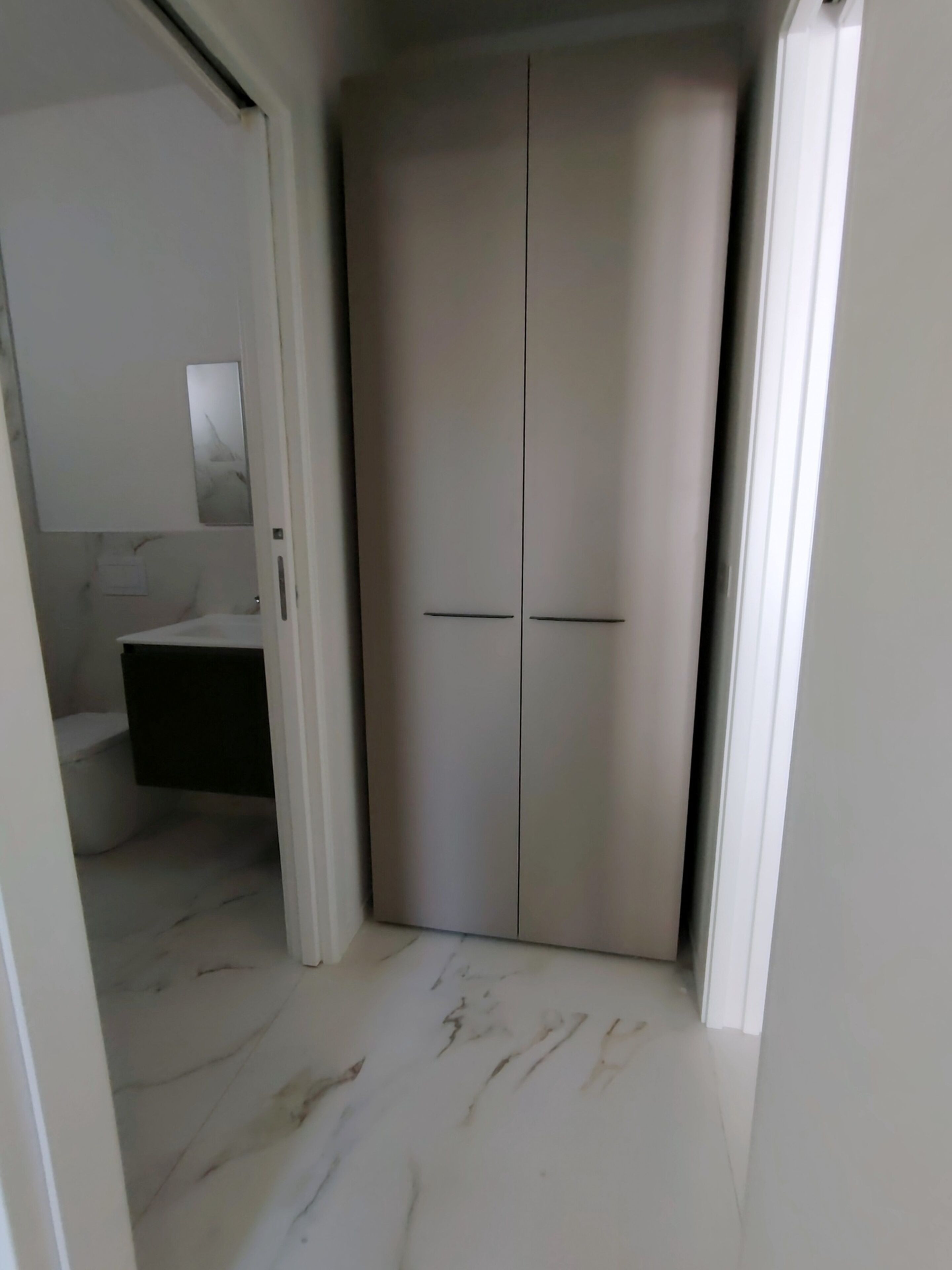 Un baño con lavamanos blanco, un espejo y un inodoro.