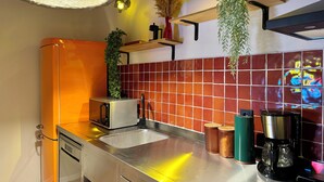 Una cocina moderna con un lavamanos de acero inoxidable, un tostador y una cafetera.