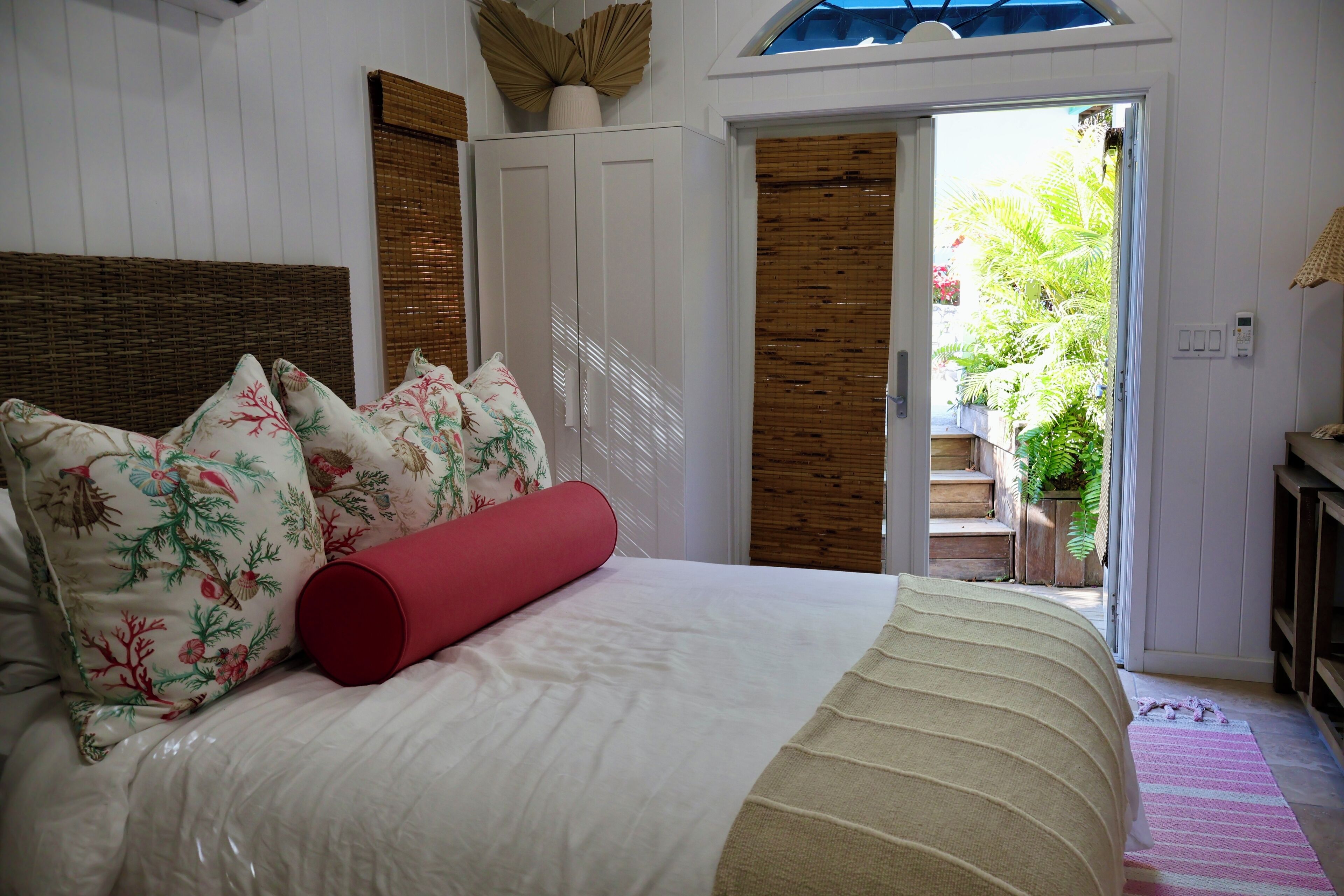 Une chambre à coucher comprenant un lit, une armoire et une porte donnant sur un balcon.