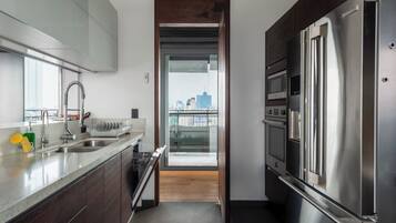 Departamento de lujo, patio, vista a la ciudad | Cocina privada | Refrigerador, microondas, horno y parrilla de estufa