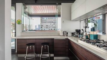 Departamento de lujo, patio, vista a la ciudad | Cocina privada | Refrigerador, microondas, horno y parrilla de estufa