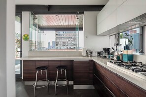 Departamento de lujo, patio, vista a la ciudad | Cocina privada | Refrigerador, microondas, horno y parrilla de estufa