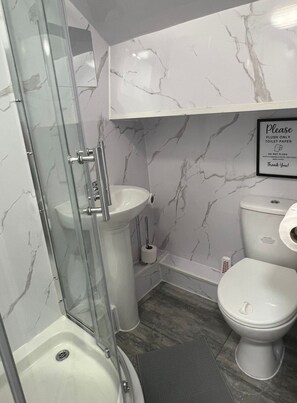 Regadera, toallas, papel de baño