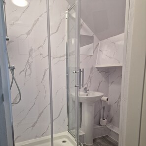 Chuveiro, toalhas de banho, papel higiênico