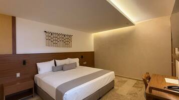 Une chambre d’hôtel moderne avec un grand lit, une table de chevet en bois, un bureau et un élément décoratif fixé au mur.
