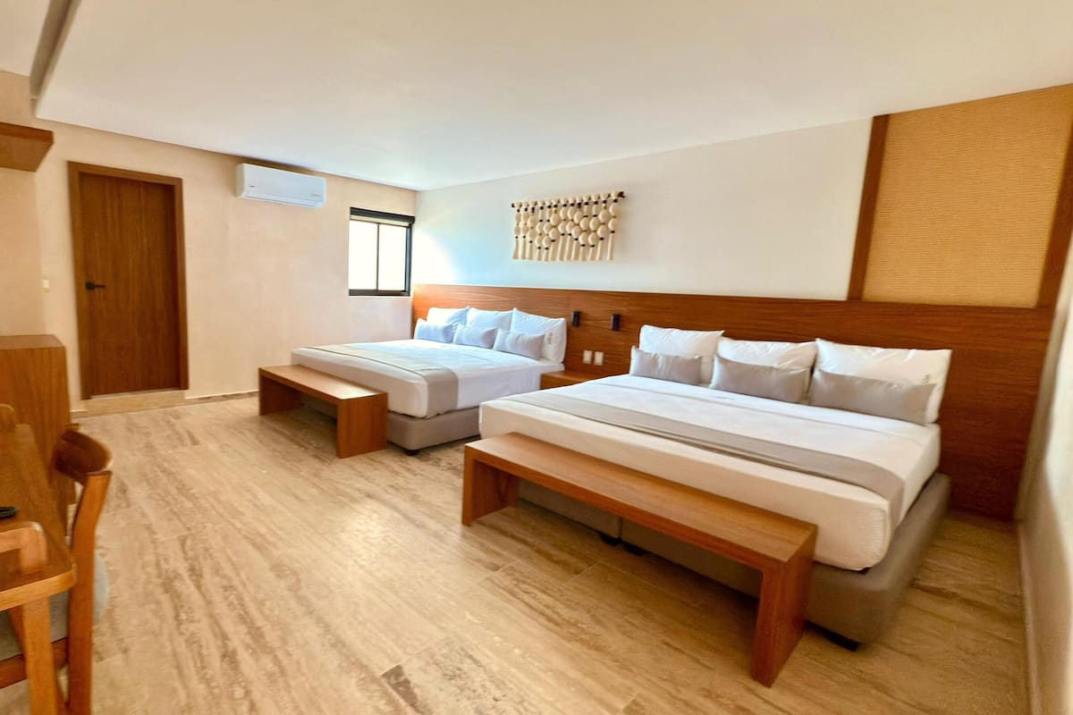 Una habitación de hotel con dos camas, un escritorio y una silla.