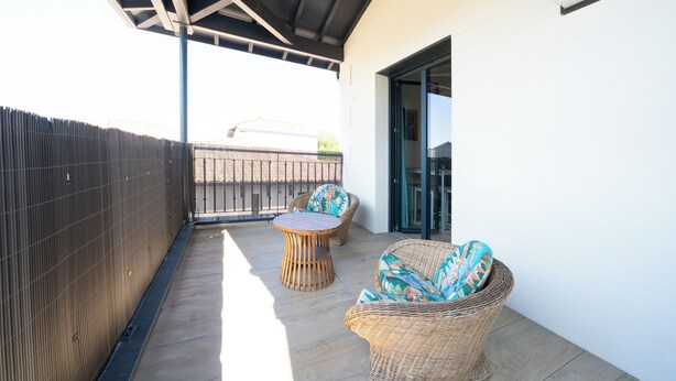 A covered outdoor area with wicker furniture and a wooden table. - La Seurinade Bassin d'Arcachon (Unknown)