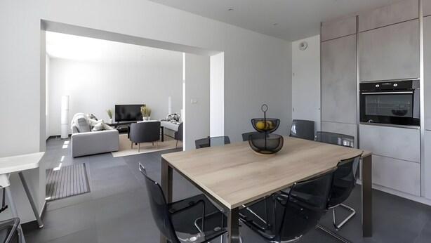 A modern kitchen with a wooden dining table, black chairs, and a built-in oven. - Farmhouse in Laigne Near Le Mans Circuit (Laigné-en-Belin)