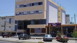 A two-story motel with a flat facade, a visible entrance, and a sign for 'Cortinas Alhambra'. - Hotel Temu (Villa Carlos Paz)