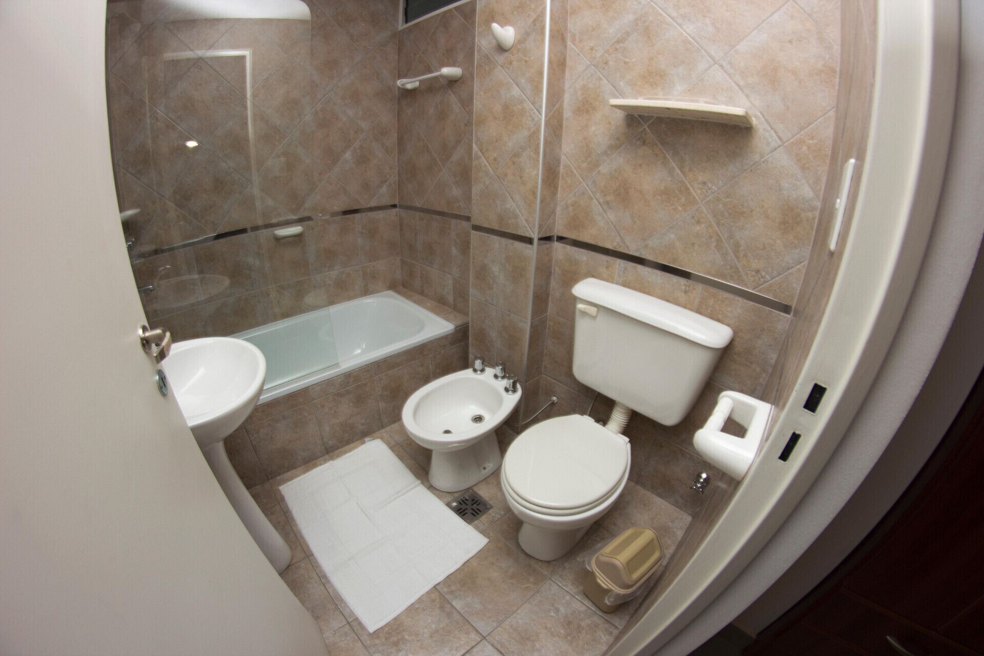 Ein Badezimmer mit einer Badewanne, zwei Toiletten, einem Bidet und einem Waschbecken.