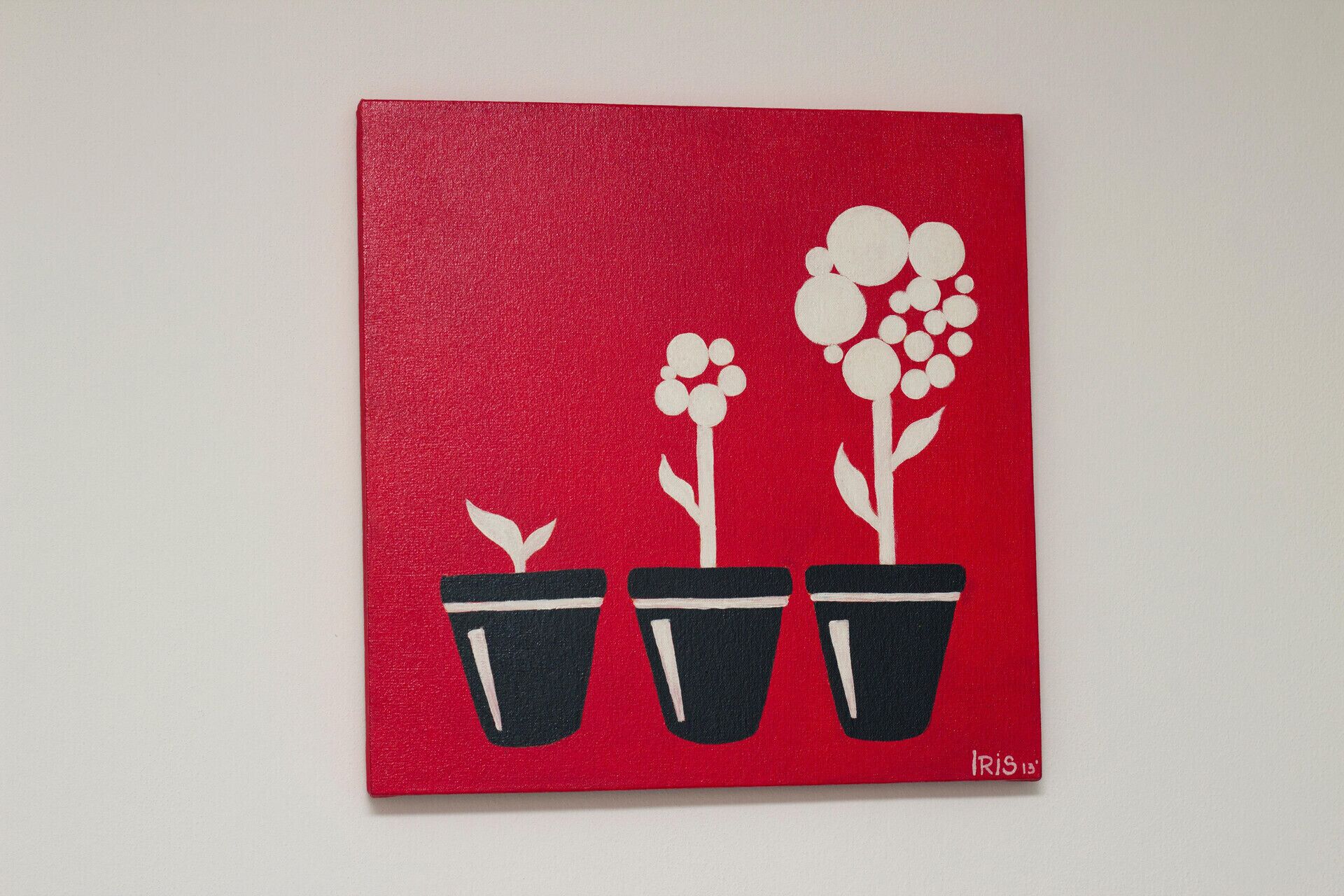 Dipinto con tre piante in vaso su sfondo rosso.