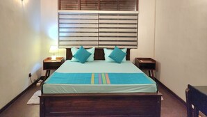 A bedroom with a bed, wooden headboard, bedside tables, a lamp, and an air conditioning unit. - 2-bedroom house in marvelous Battaramulla with WiFi, AC (Battaramulla)