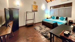 A bedroom with a bed, a desk, a chair, a hanging rack, a painting, and a ceiling fan. - 2-bedroom house in marvelous Battaramulla with WiFi, AC (Battaramulla)