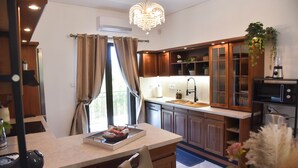 A modern kitchen with wooden cabinets, a central island, and a chandelier.