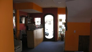 Een receptie met een bureau, een balie en uitzicht op de straat door een gebogen doorgang.