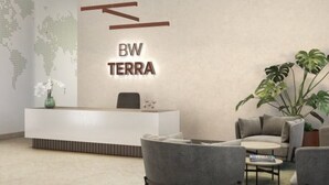 A modern reception area with a minimalist design, featuring a reception desk, seating area, and a world map on the wall.