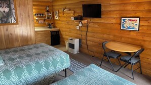 A cozy cabin with two beds, a small kitchenette, a TV, and a map on the wall. - Wolf Cabin-Modern Comfort in the Last Frontier (For families or casual travelers) (Tok)
