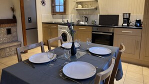 A dining area with a table set for four, including plates, glasses, and cutlery. - Chalet in Aubigne-racan With Pool & Garden (Aubigne-Racan)