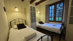 A bedroom with two single beds, a window with curtains, and wall-mounted lamps. - Chalet in Aubigne-racan With Pool & Garden (Aubigne-Racan)