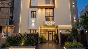 Un hotel con fachada moderna, varios ventanales y un letrero que dice 'Jay & Jas Hotel'.