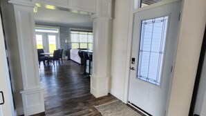 A hallway with dark wooden flooring, white walls, and a black geometric ceiling light fixture. - Cozy Waterfront Country Home w/game room. Close to all amenities! (Lot 19)