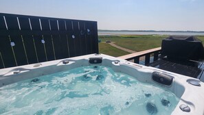 Un jacuzzi en una terraza con vistas a un lago.