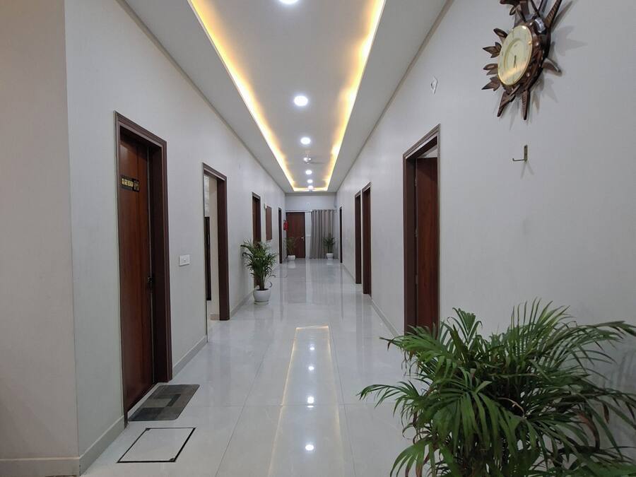 A long, well-lit hallway with a ceiling fan, recessed lighting, and a decorative wall clock.