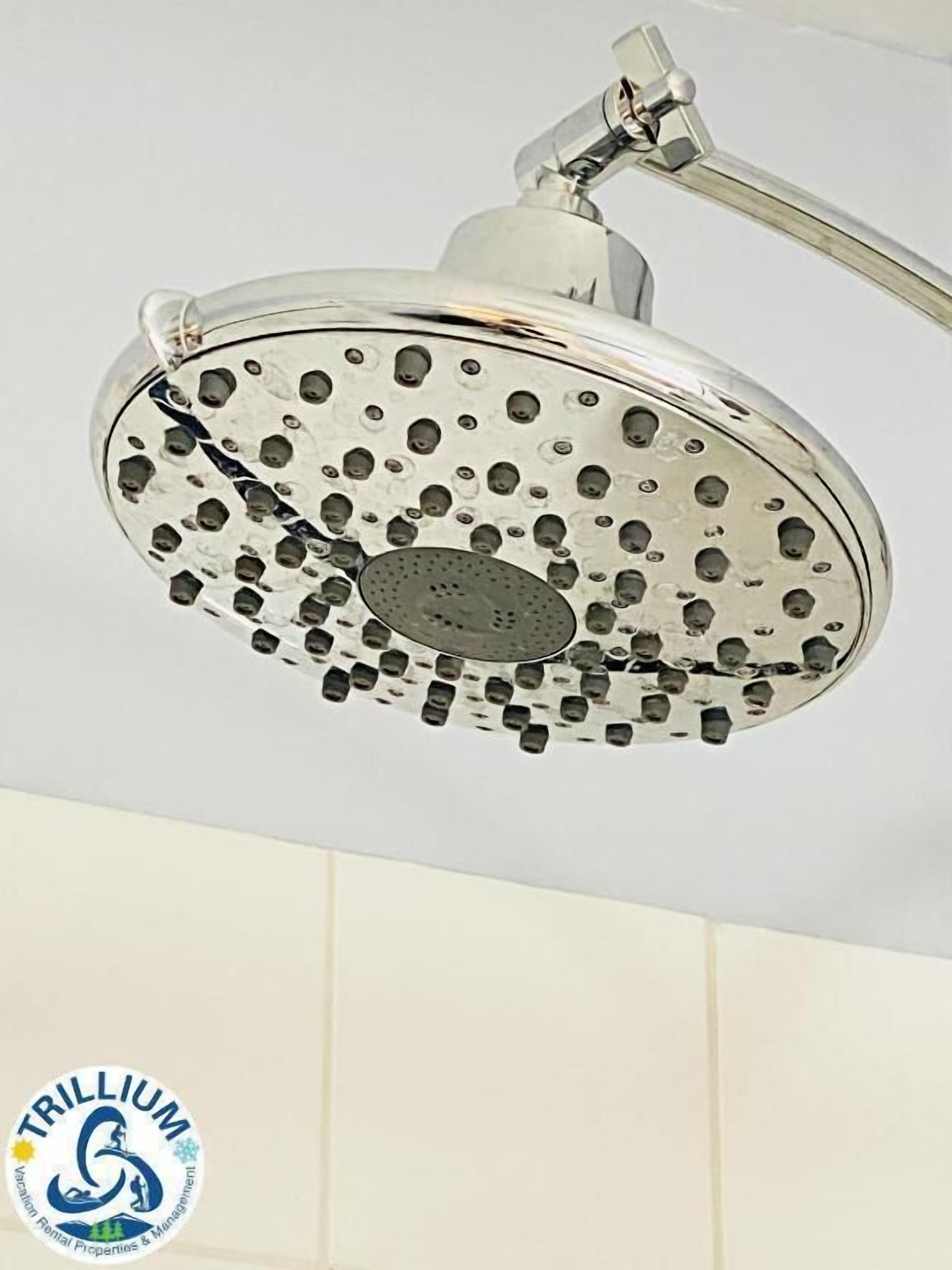 A modern showerhead with multiple nozzles, mounted on a wall.