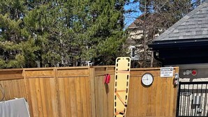 A hot tub with a metal ladder, surrounded by a wooden deck and a fence. - Cozy Studio Loft with 2 Bath (Blue Mountain)