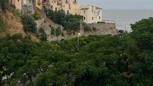A coastal town with buildings on a hillside, a clear sky, and the sun setting or rising. - Cozy Double Room with Sea and Mountain view Terrace (Diamante)