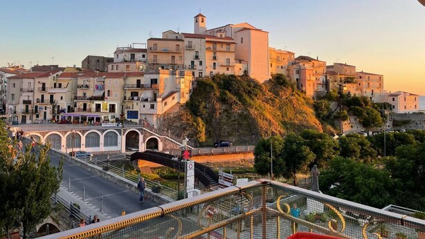 A coastal town with historic buildings, a prominent church tower, and a pedestrian bridge. - Cozy Double Room with Sea and Mountain view Terrace (Diamante)