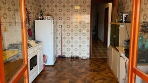 A kitchen with patterned wallpaper, a refrigerator, a stove, and a tiled floor. - Cozy Double Room with Sea and Mountain view Terrace (Diamante)