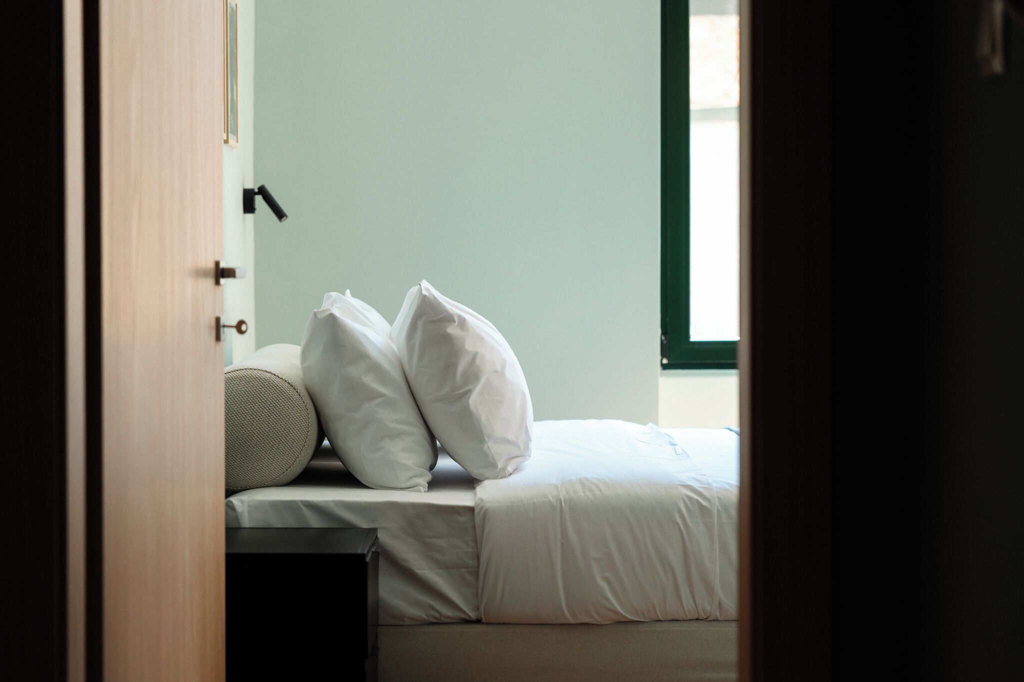 Une chambre à coucher avec un lit, des oreillers et une table de chevet.