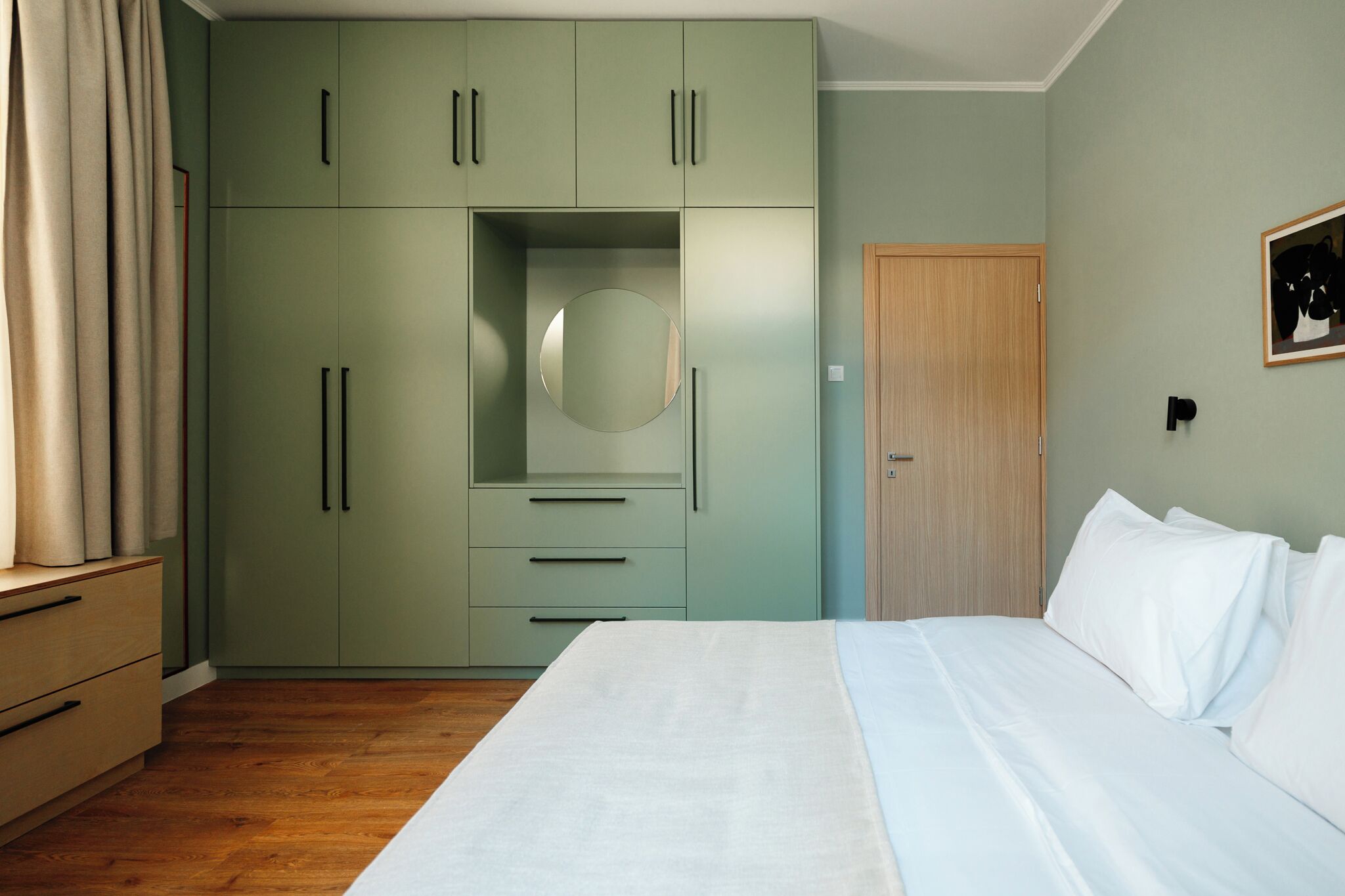 A bedroom with a bed, a wardrobe, and a door.