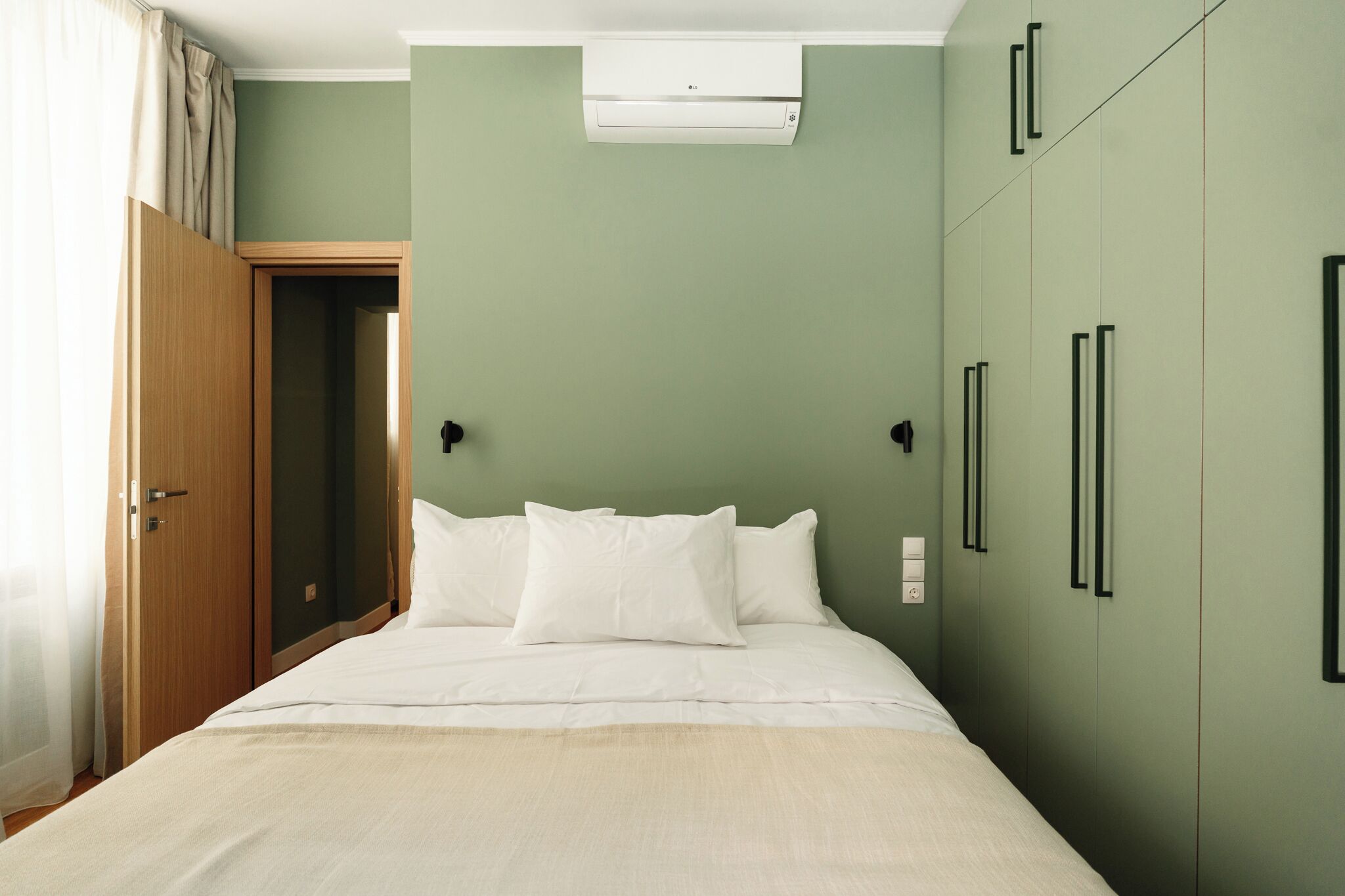 Un dormitorio con cama, armario y aire acondicionado.
