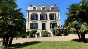A two-story building with a symmetrical facade, a central entrance with steps, and a small balcony on the second floor. - Estate in Saint-pavace Near Le Mans Circuit (Saint-Pavace)