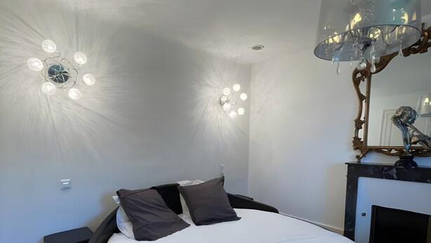 A modern bedroom with a circular bed, a large mirror, and a unique ceiling light fixture. - Estate in Saint-pavace Near Le Mans Circuit (Saint-Pavace)