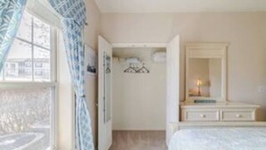 A bedroom with a bed, a dresser, a mirror, and a closet.