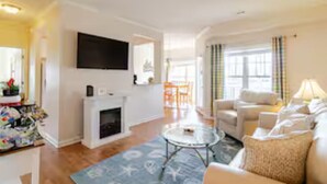 A living room with a fireplace, a television, a sofa, and a coffee table.