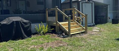 A residential property with a covered porch, a garage, and a small shed.