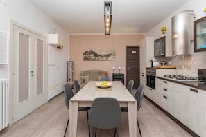 Uma cozinha moderna com uma mesa de jantar, cadeiras e uma ilha central.