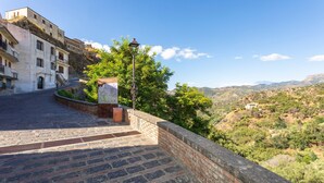 A stone staircase leading to a building with a view of a hilly landscape. - 'Executive Suite' room with private balcony, sea view, Wi-Fi and air conditioning (Savoca)